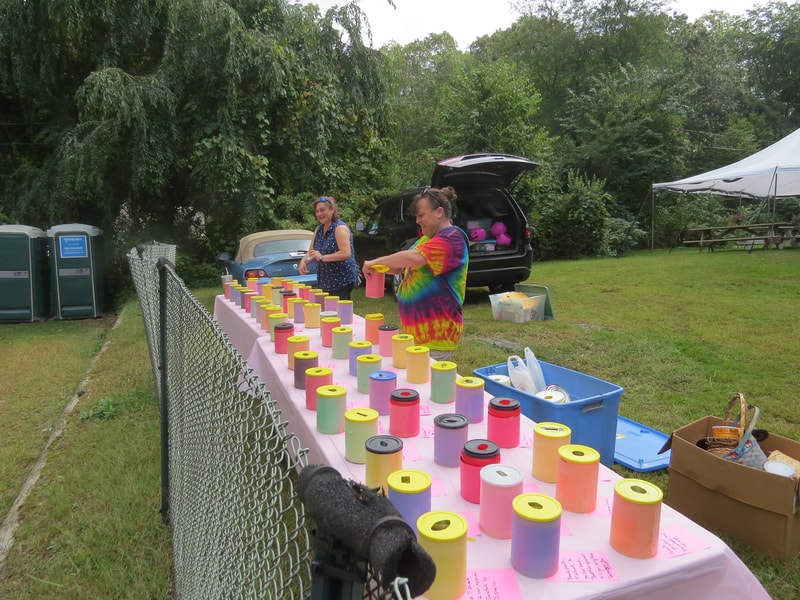 Colorful painted donation jars being set up on a long table