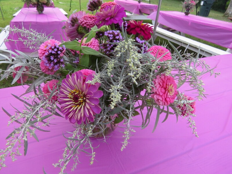 Beautiful pink and magenta flower centerpiece on a pink tablecloth at Boobstock